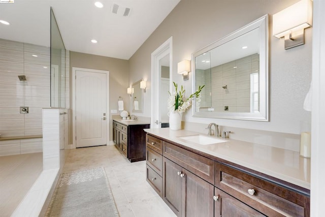 bathroom with vanity and a tile shower