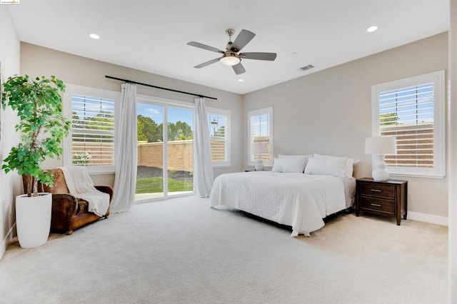 carpeted bedroom with ceiling fan, multiple windows, and access to outside