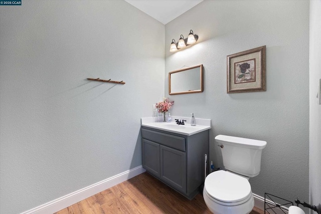 bathroom with hardwood / wood-style flooring, vanity, and toilet