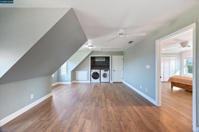 bonus room with hardwood / wood-style floors, washing machine and dryer, and ceiling fan