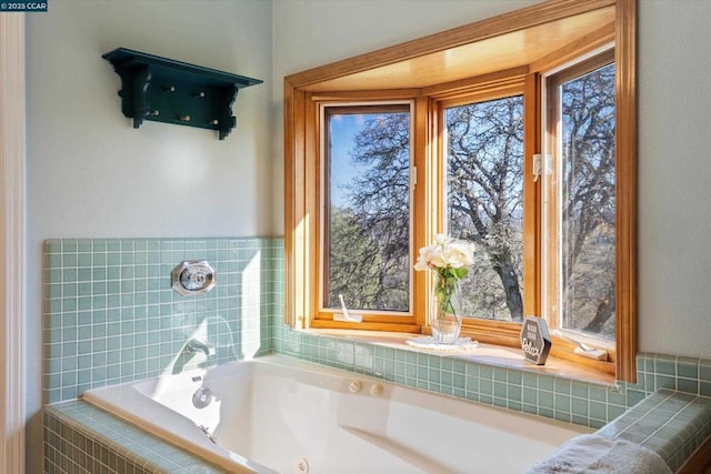 bathroom featuring plenty of natural light and tiled bath