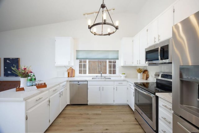 kitchen featuring stainless steel appliances, decorative light fixtures, sink, and white cabinets