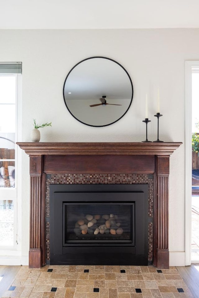 details with ceiling fan and a fireplace