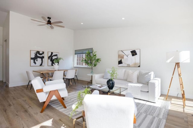 living room featuring lofted ceiling, light hardwood / wood-style floors, and ceiling fan