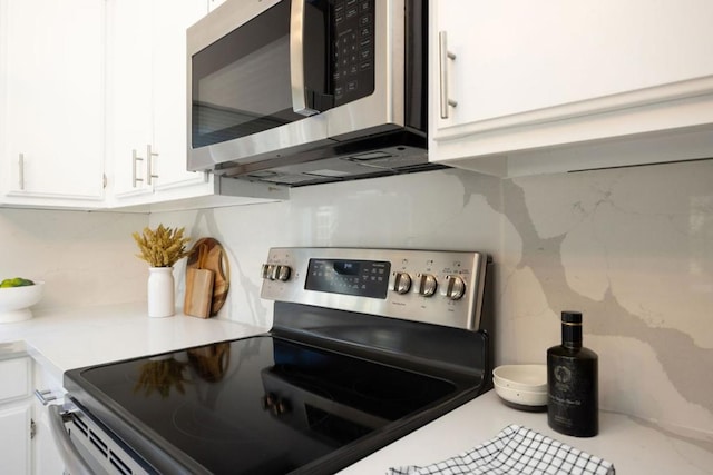 kitchen featuring white cabinetry, appliances with stainless steel finishes, and backsplash