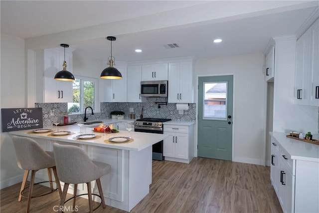 kitchen featuring stainless steel appliances, white cabinetry, sink, and backsplash