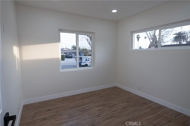 spare room with dark hardwood / wood-style floors and a healthy amount of sunlight