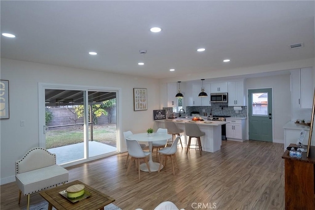 living room with hardwood / wood-style floors, a wealth of natural light, and sink