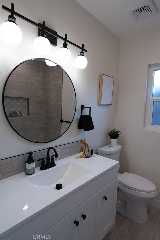 bathroom with hardwood / wood-style flooring, vanity, and toilet