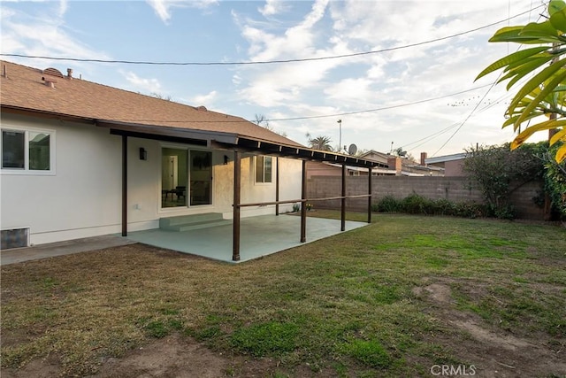 rear view of property with a yard and a patio