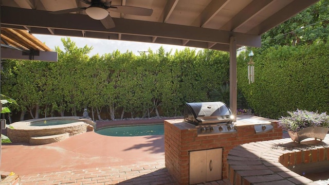 view of patio / terrace with a pool with hot tub, grilling area, and exterior kitchen