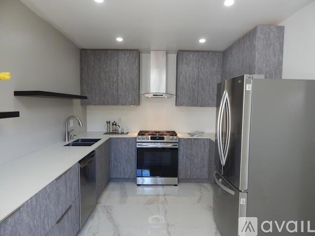 kitchen featuring stainless steel appliances, sink, and wall chimney range hood