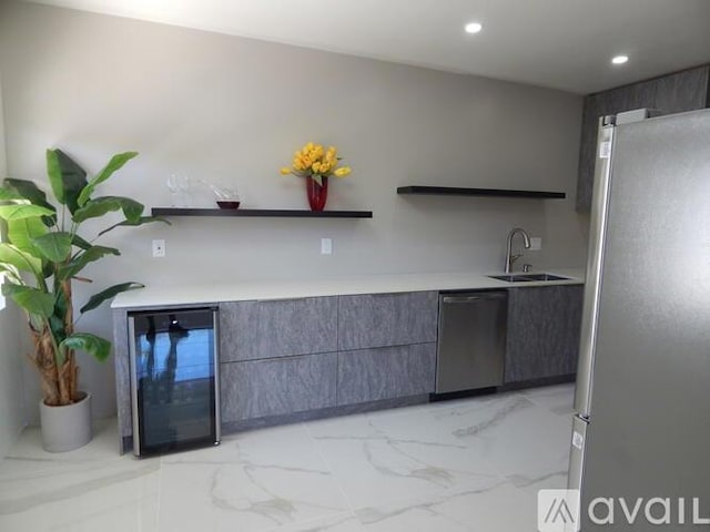 kitchen featuring wine cooler, stainless steel appliances, and sink