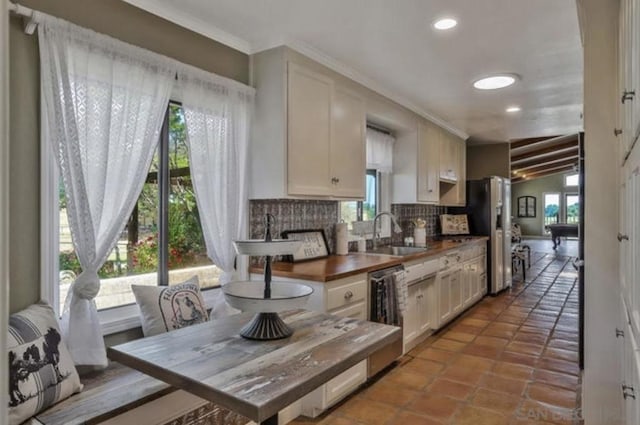 kitchen featuring white cabinetry, dishwasher, sink, and tasteful backsplash