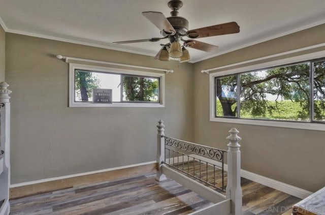 bedroom with hardwood / wood-style flooring, ornamental molding, and ceiling fan