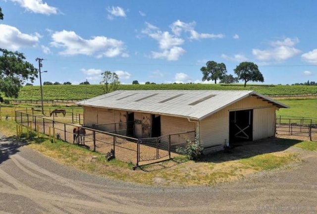 view of horse barn featuring a rural view