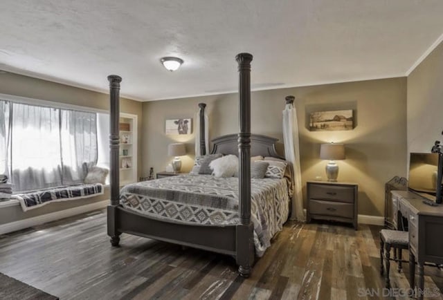 bedroom featuring dark wood-type flooring, crown molding, and a wood stove