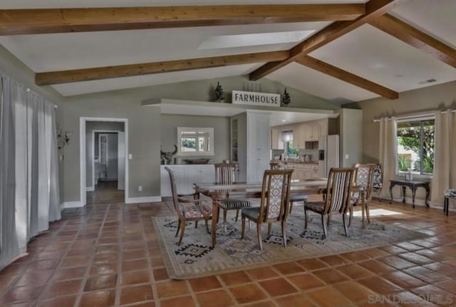 tiled dining room featuring lofted ceiling with beams