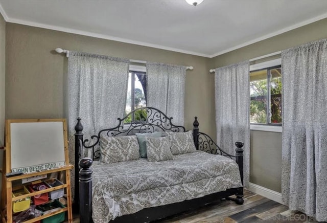 bedroom with ornamental molding and hardwood / wood-style floors