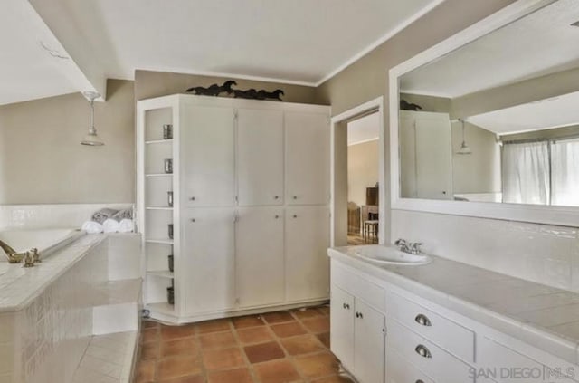 bathroom featuring vanity, tiled tub, and tile patterned flooring