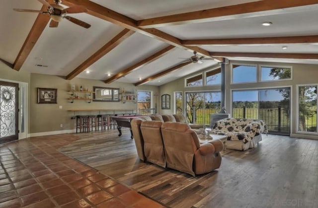 living room featuring plenty of natural light, dark wood-type flooring, bar, and beam ceiling