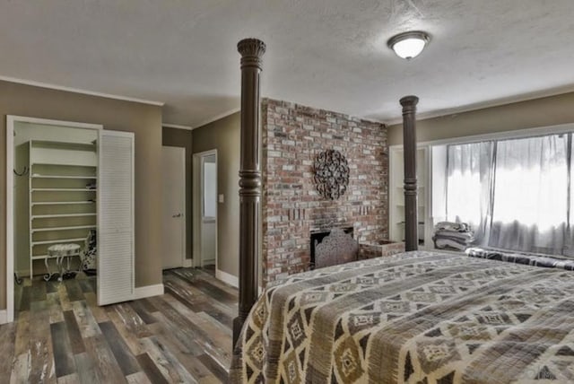 bedroom featuring crown molding, dark hardwood / wood-style flooring, and a textured ceiling