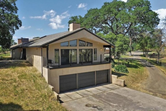 back of property with a yard and a garage