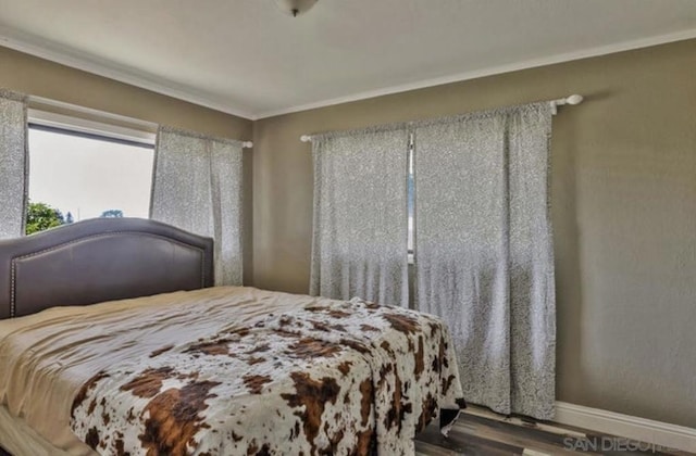 bedroom featuring hardwood / wood-style flooring and crown molding