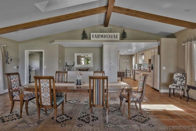 tiled dining space with lofted ceiling with beams