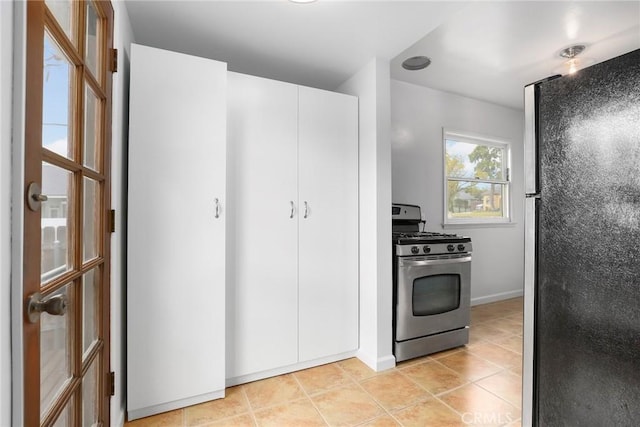 kitchen with white cabinetry, stainless steel appliances, and light tile patterned floors