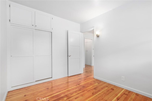 unfurnished bedroom with a closet and light hardwood / wood-style flooring