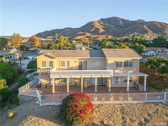 back of house with a patio area, a mountain view, and central AC unit