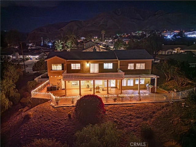 back of house at twilight featuring a patio area and a fenced backyard