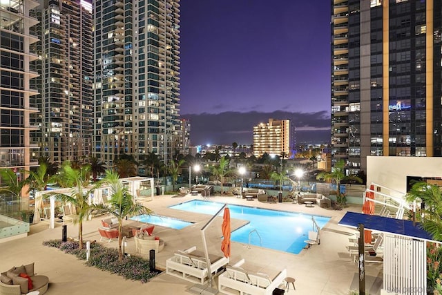 pool at dusk featuring a patio area