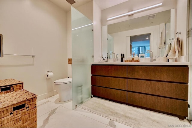 bathroom featuring vanity, a shower with shower door, and toilet