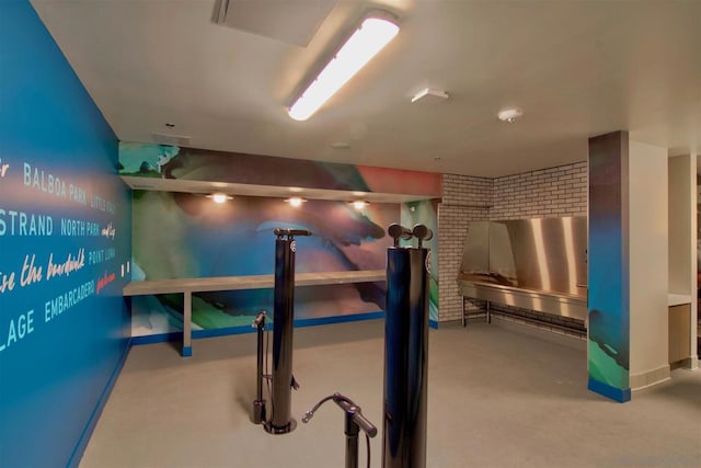 basement featuring brick wall and carpet flooring