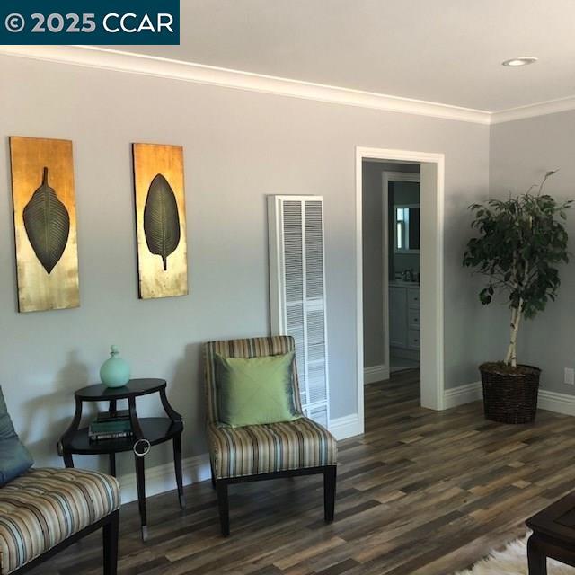 sitting room with crown molding and dark hardwood / wood-style floors