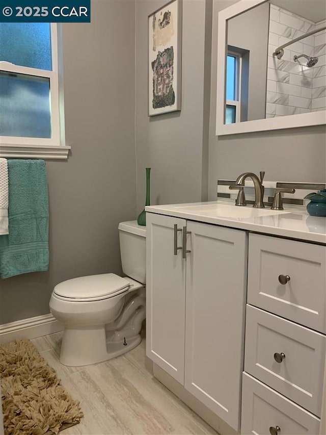 bathroom featuring vanity, toilet, and tiled shower