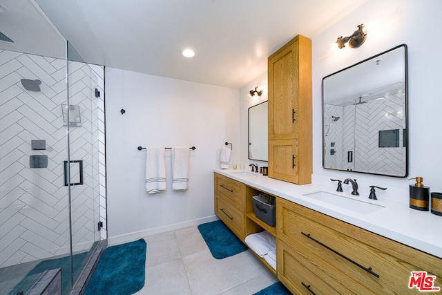 bathroom with a shower with door, vanity, and tile patterned flooring