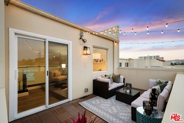 balcony at dusk featuring an outdoor hangout area