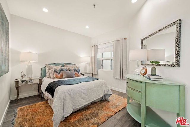 bedroom with dark hardwood / wood-style floors