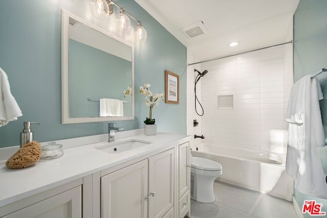 full bathroom featuring tile patterned flooring, tiled shower / bath, vanity, and toilet