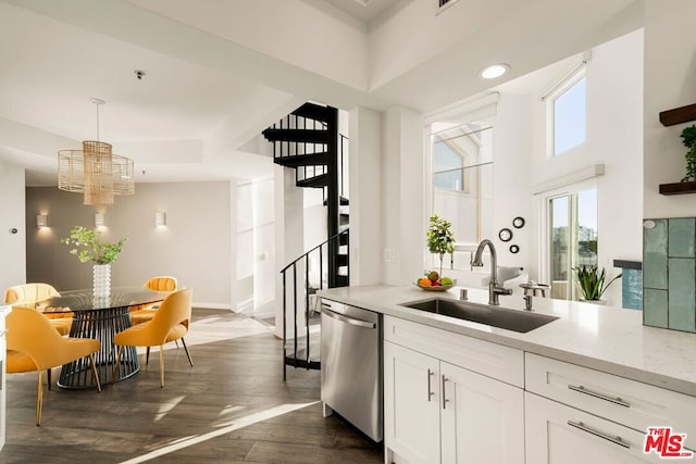 kitchen with dark hardwood / wood-style floors, decorative light fixtures, white cabinetry, dishwasher, and sink