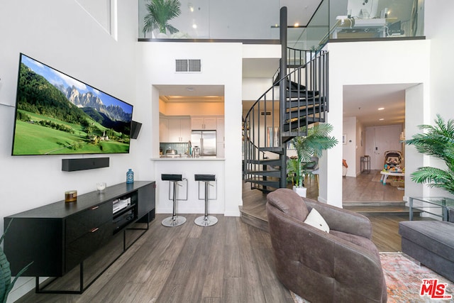 living room with hardwood / wood-style floors and a high ceiling