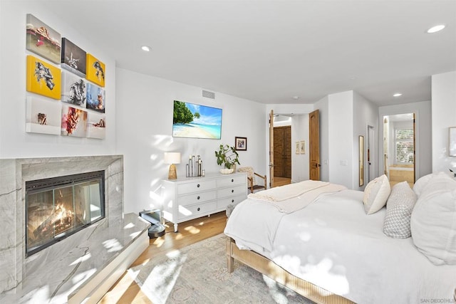 bedroom featuring a fireplace and light hardwood / wood-style floors