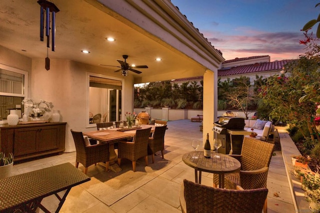 patio terrace at dusk with a grill and ceiling fan