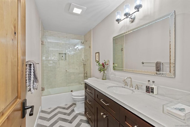 full bathroom featuring shower / bath combination with glass door, vanity, and toilet