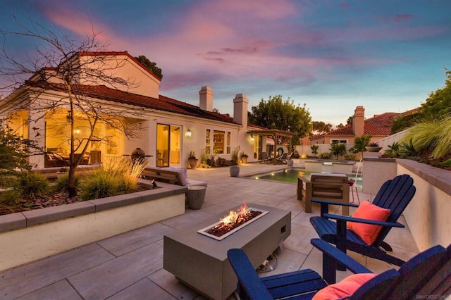 patio terrace at dusk featuring an outdoor fire pit