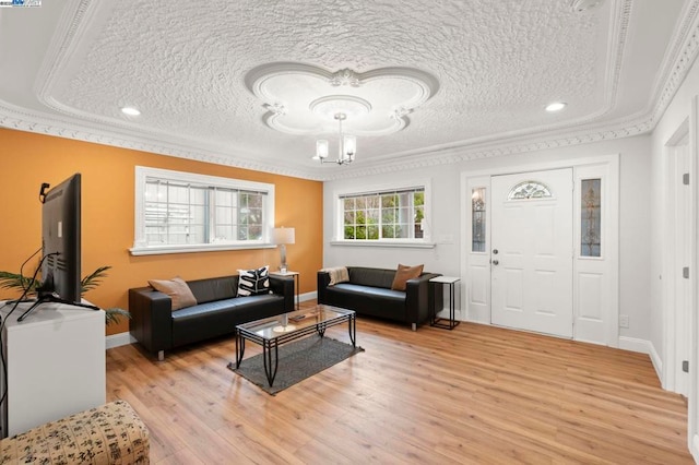 living room with ornamental molding, a textured ceiling, and light hardwood / wood-style floors