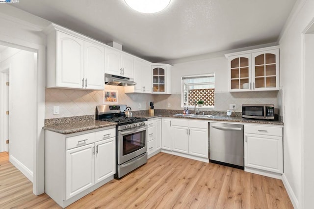 kitchen with white cabinetry, appliances with stainless steel finishes, sink, and light wood-type flooring